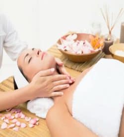 Female receiving light aromatherapy massage to neck area