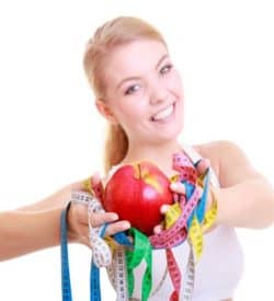 Slimming Massage course at Bali BISA. Pictures is a woman holding apple and measuring tapes so checking the success of slimming massage