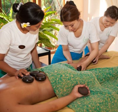 Bali BISA explaining to students about warm stone massage on the legs